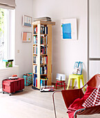 Red leather armchair in Mattenbiesstraat family home with revolving bookshelf and toy box on wheels, Netherlands