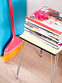 Magazines on side table with broom in Mattenbiesstraat family home, Amsterdam, Netherlands