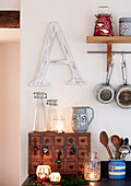 Large letter 'A' with wooden storage and utensils in kitchen of Devonshire farmhouse UK