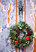 Christmas wreath with pinecones on weathered London door England UK