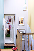 Abgenutzter Handlauf auf Treppenabsatz mit Blick ins Badezimmer eines Londoner Einfamilienhauses England UK