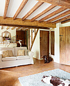 Two dogs in living room of beamed Surrey farmhouse living room England UK