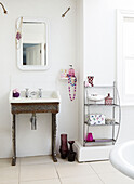 Metal washstand with shelf unit in white bathroom of London townhouse England UK