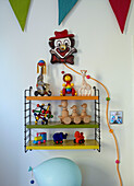 Wall mounted shelving with toys in child's room of family home in Margate Kent England UK
