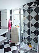 Glasduschkabine in einem schwarz-weiß karierten Badezimmer in einem Einfamilienhaus in Margate, Kent, England, UK
