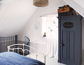 Grey painted wardrobe in attic bedroom of schoolhouse conversion Brittany France