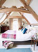 Dachgeschoss-Schlafzimmer mit Balken in einer umgebauten Scheune in Nottinghamshire England UK