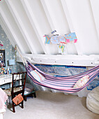 Gestreifte Hängematte und Balkendecke im Schlafzimmer im Dachgeschoss einer umgebauten Scheune in Nottinghamshire England UK