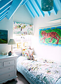 Tiger-Kunstwerk über dem Einzelbett im Zimmer des Jungen in einer umgebauten Scheune in Nottinghamshire England UK