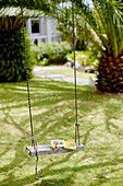 Story book and toy on tree swing in Warkworth garden Auckland North Island New Zealand