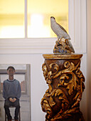 Vogelstatue auf geschnitzter, antiker Säule mit Kunstwerk auf Leinwand in einem Haus in Notting Hill, West London UK