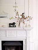 Berries and twigs with lion statue on Bicester mantlepiece Oxfordshire England