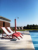 Red sunloungers at poolside in Brittany France