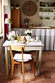 Vintage chair at breakfast table with cut flowers in Brittany farmhouse France