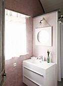 Spiegel über dem Waschbecken mit einer einblättrigen Blume an einer Trennwand in der Bretagne, Frankreich
