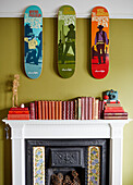 Pop art with hardbacked books above Victorian fireplace in Kent home England UK