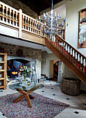 Glass topped table in entrance hall of Northumbrian manor house with carved wooden banisters England UK