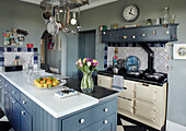 Cut tulips and fruit bow with cream Aga in Northumbrian manor house kitchen England UK