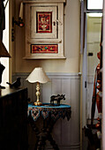 Handbemalter Wandschrank über einem Tisch mit Perlenstickerei in Whitley Bay cottage Tyne and Wear, England, UK