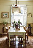 Cut flowers on dining table with wooden chairs in Whitley Bay home Tyne and Wear England UK