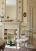 Cream mirror and fireplace with handbag on chair on Whitley Bay cottage Tyne and Wear England UK