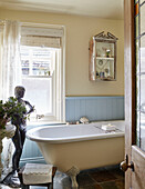 Figurine at foot of freestanding bath in light blue Whitley Bay bathroom Tyne and Wear England UK