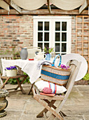 Picnic basket and cushion on folding chair on Northumbrian terrace exterior England UK