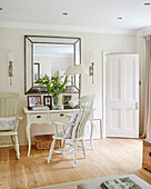 Painted chairs at desk with large square mirror in Northumbrian home England UK