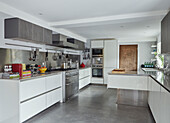 Stainless steel oven and cupboards in kitchen of 19th Century Grain Mill conversion Scottish Borders, UK
