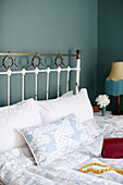 Vintage metal headboard with light blue quilt and pillow in Birmingham home England UK