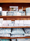 Cards cushions and wrapping paper on shelving in textile designers' Birmingham work studio England UK
