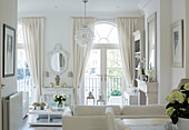 Glass chandelier hangs in white living room of York townhouse England UK