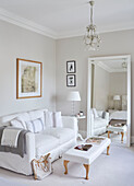 White sofa and footstool with full length mirror in York townhouse England UK