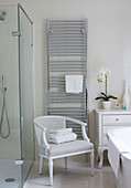 Gefaltete Handtücher auf einem gestreiften Sessel mit beheiztem Heizkörper in einem Badezimmer in York, England, UK