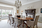 Dining chairs at table with carved wooden fireplace in Northumbrian country house UK