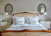 Ein Paar Spiegel und Lampen an einem Bett aus Korbgeflecht in einem Landhaus in Northumbria UK