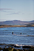 Two boys in wetsuits with bodyboards in the sea County Sligo Connacht Ireland