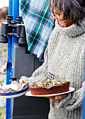 Frau serviert Schokoladenkuchen vom Rücksitz eines 4x4-Geländewagens in der Grafschaft Sligo Connacht Irland