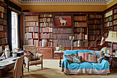 Quilted throw over sofa in library study of Capheaton Hall, Northumberland, UK