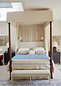 Wooden four poster bed with light blue cover in Capheaton Hall, Northumberland, UK