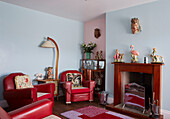 red leather armchairs with ornaments on fireplace in County Durham home, North East England, UK
