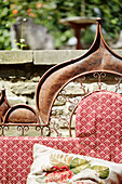 Ironwork seat with Victorian fabric in garden of Georgian home in Talgarth, Mid Wales, UK