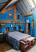 Double bed in blue timber framed bedroom in Herefordshire farmhouse, UK