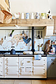 Jugs on shelf above cream oven with farmyard animals in Warwickshire home, UK