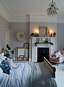 Double bed with lit candles and pink armchair in East Grinstead home, West Sussex, UK