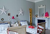 Lit tealights on fireplace in child's twin room with stars above beds East Grinstead home, West Sussex, UK