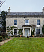 Lawned exterior and facade of Regency home in the Cotswolds, England, UK