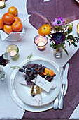 Cut flowers at personalised table setting for Christmas dinner in London home, UK