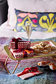 Champagne and mince pies with gift wrapped presents on breakfast tray in London home, UK