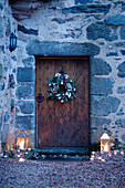 Beleuchtete Laternen an der alten hölzernen Eingangstür eines schottischen Schlosses, UK